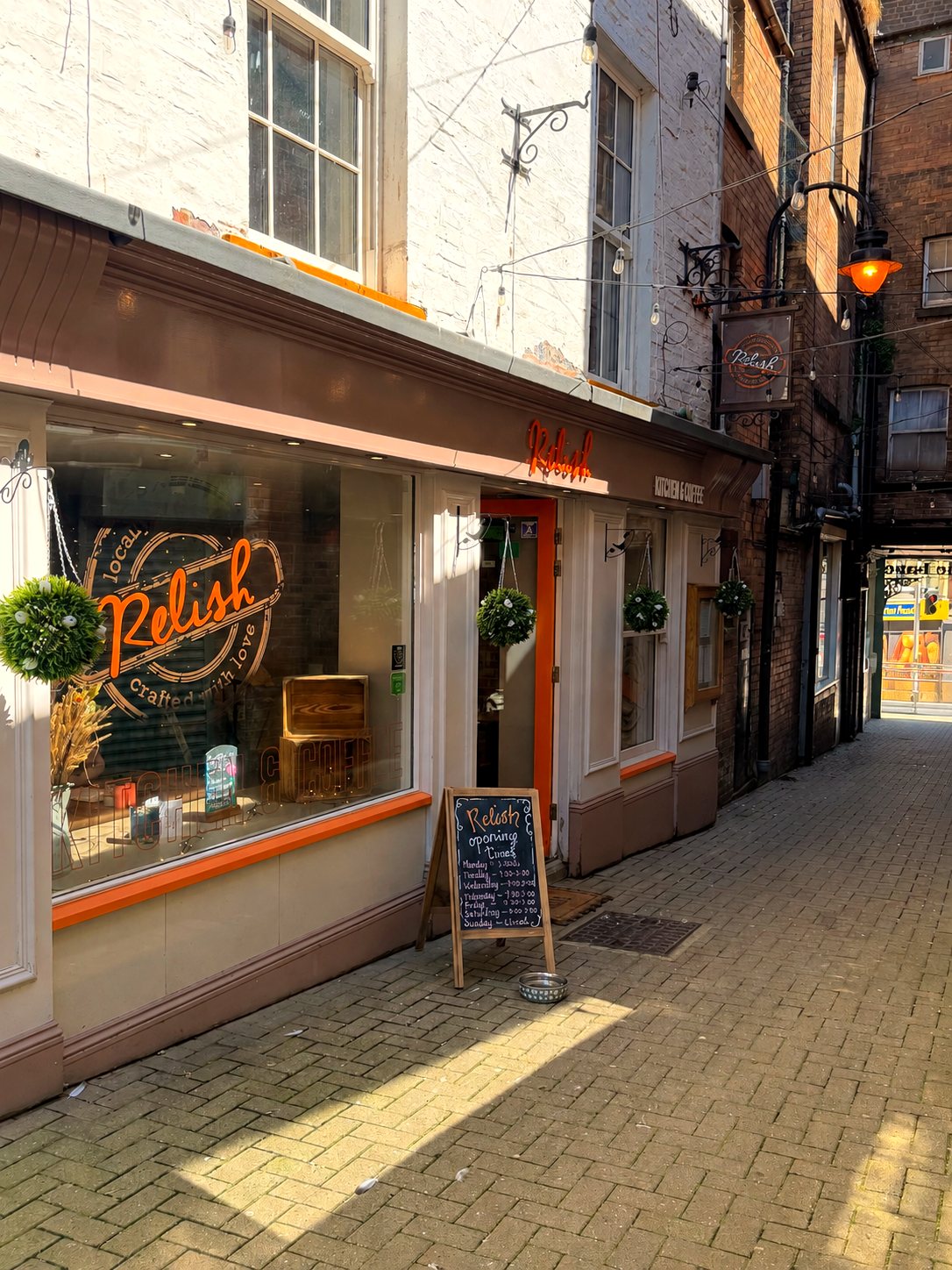 The Relish shopfront on Waterhouse Lane with its orange sign and chalkboard